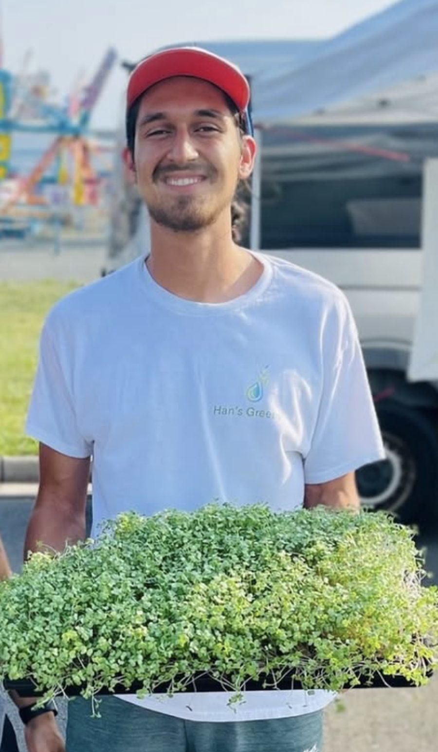 Han holding a tray of freshly grown microgreens